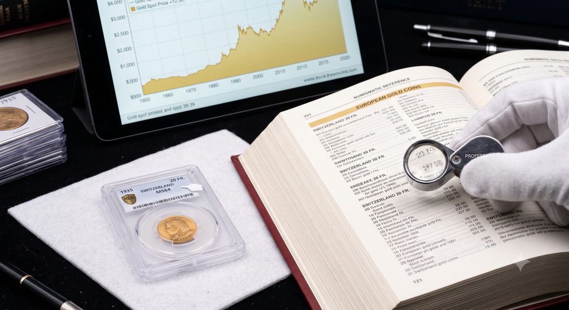 A slabbed gold coin beside a numismatic reference book and a gold market price chart