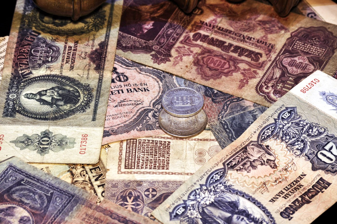 A pile of vintage foreign paper currency and a silver coin