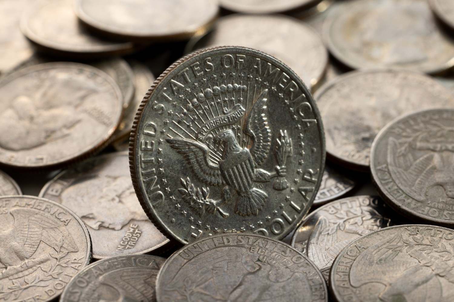 A pile of Morgan and Peace silver dollars