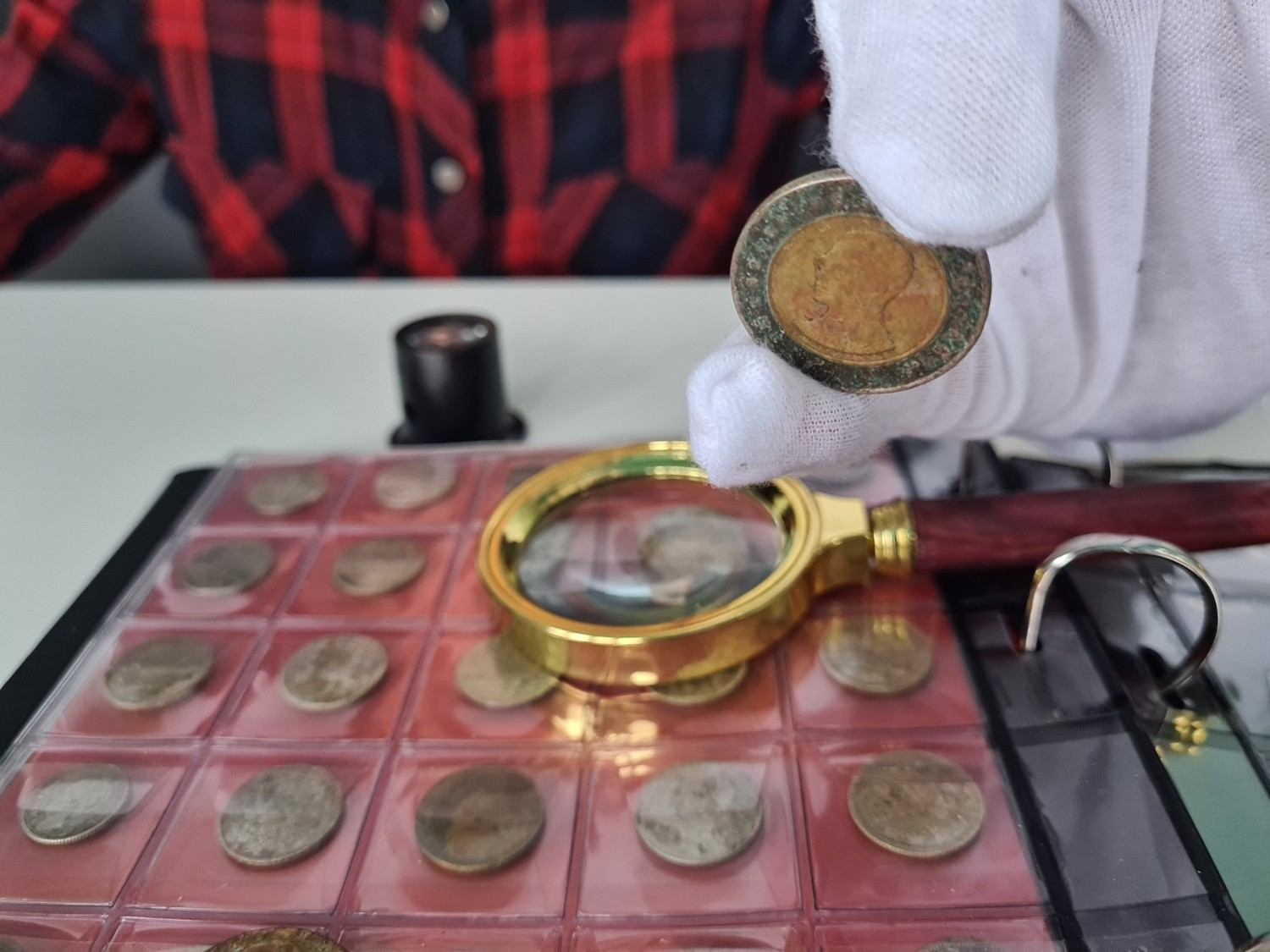 A mixed collection of coins, currency, and stamp albums spread on a table